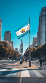 Sunlit city boulevard crowned by a proud blue-white flag.