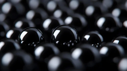 Glossy black spheres fill frame with shallow depth of field