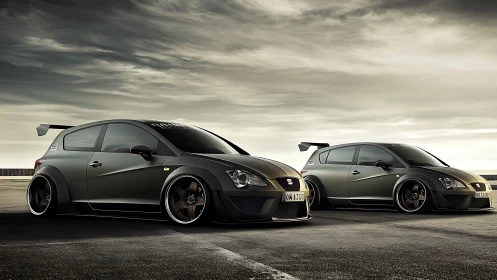 Twin widebody hatchbacks with aero kits on coastal tarmac