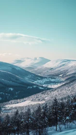 Snow covered mountain valley stretches under clear winter sky