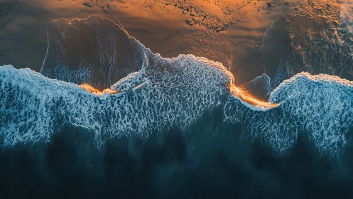 Aerial surf line lit by golden coastal sunset glow.