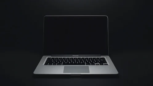 Minimalist silver laptop under low key optical isolation.