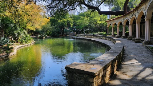 Curved riverside colonnade frames reflective urban garden pond