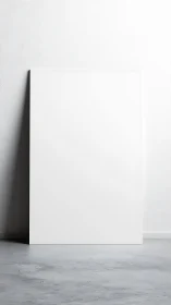 Large blank vertical canvas leans on textured wall in minimal studio