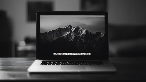 Laptop displays monochrome mountain range desktop wallpaper