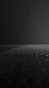 Nocturnal asphalt horizon under sparse reflective rainfall.