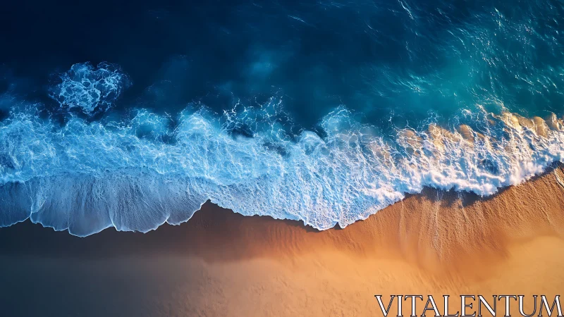 Aerial ocean surf meeting smooth golden sandy shore.