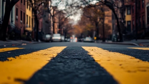 Low street perspective with bold yellow lane markings at dusk.