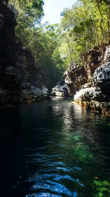 Narrow rock gorge channels dark river with specular light reflections