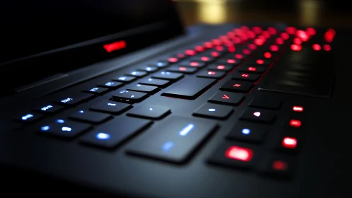 Backlit gaming laptop keyboard glows in a darkened room
