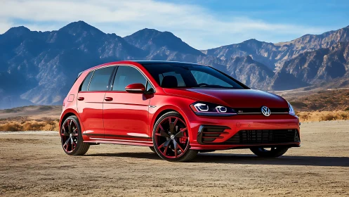 Red sport hatchback car stands in sharp contrast to arid mountains