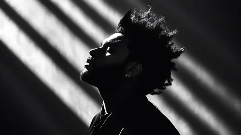 Monochrome profile portrait in dramatic raking key light.