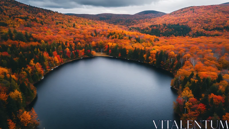 Curved forest lake embraced by vivid autumn mountainscape.