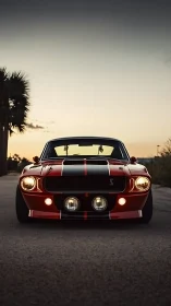 Red classic muscle car parked on empty road at dusk.