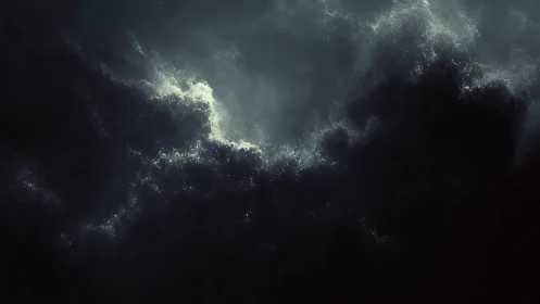 Dark storm cloud mass with pale light breaking through.