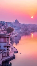 Sunset bathes riverside Indian cityscape in soft pastels.