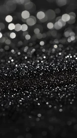 Black glitter surface with defocused silver bokeh lights