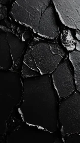 Macro closeup of fractured black rock with glossy wet texture