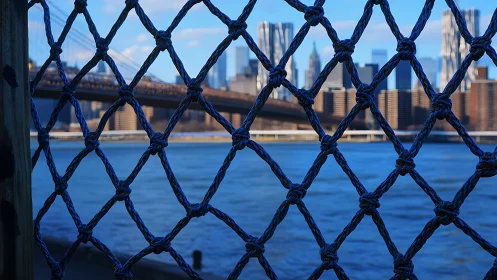 Shallow depth urban skyline beyond knotted rope barrier grid