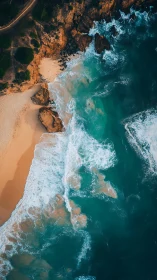 Crashing turquoise surf along rugged golden coastline aerial.