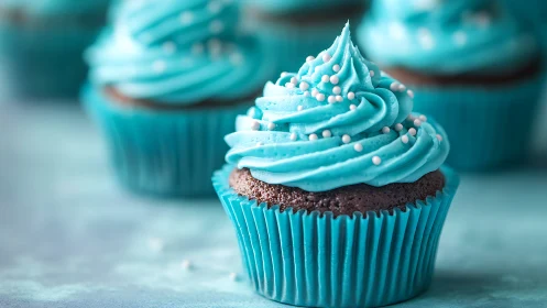 Turquoise frosted chocolate cupcake with pearl decorations.