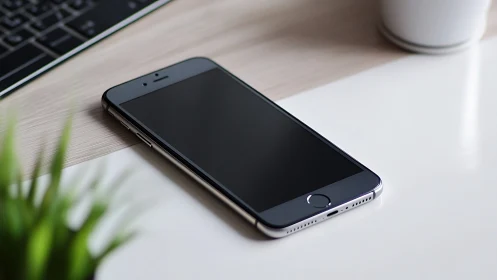 Smartphone on wooden desk with workspace peripherals