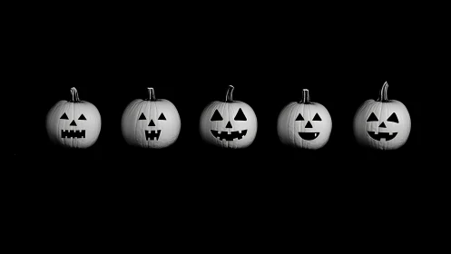 Monochrome jack-o-lantern lineup in minimal studio lighting.