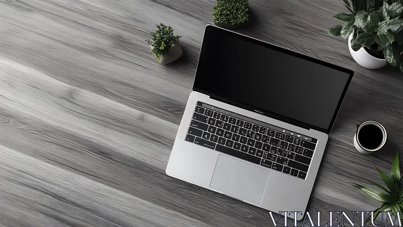 Laptop on gray wooden desk with plants and black coffee mug