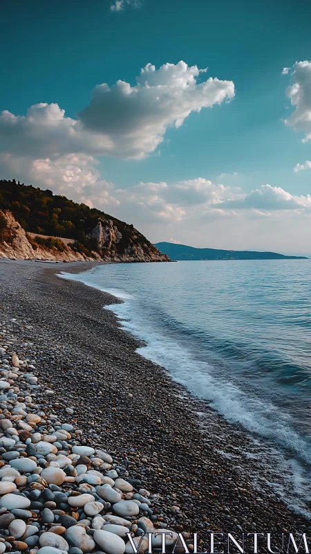 Rocky shoreline curves under teal sky and soft clouds.