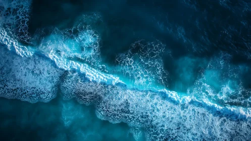 Crestline of turquoise surf carving patterns in deep sea blue.