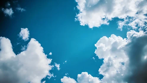Bright blue sky with fluffy white clouds in natural daylight.