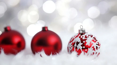 Red glass ornaments on white surface with soft bokeh background.