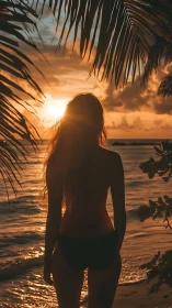 Silhouetted woman studies tropical sunset through palm fronds