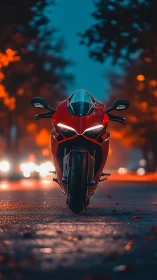 Red sport motorcycle on wet city street at dusk.