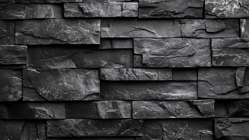 Dark stacked slate stone wall with rough textured surface.