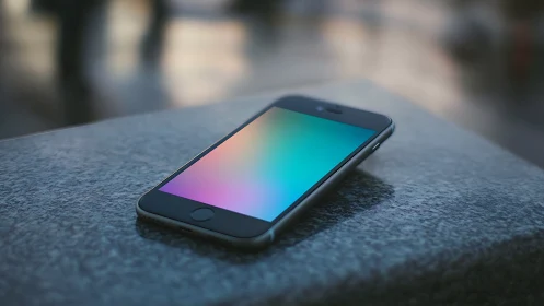 Smartphone with gradient display on concrete surface.