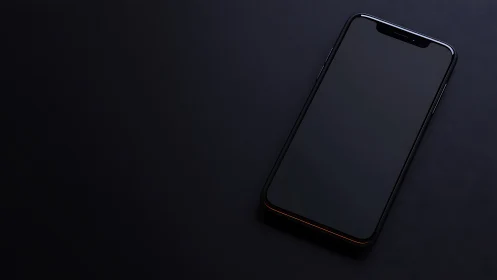 Dark smartphone with notch on black surface.