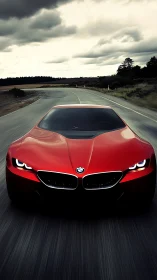 Red BMW sports car driving fast on empty rural highway.