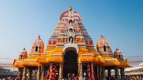 Colorful Hindu temple shikhara rises over festive courtyard.