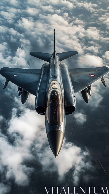 Military jet flies above dense cloud layer in daylight sky