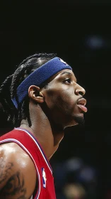 Profile view of basketball player in red jersey on court.