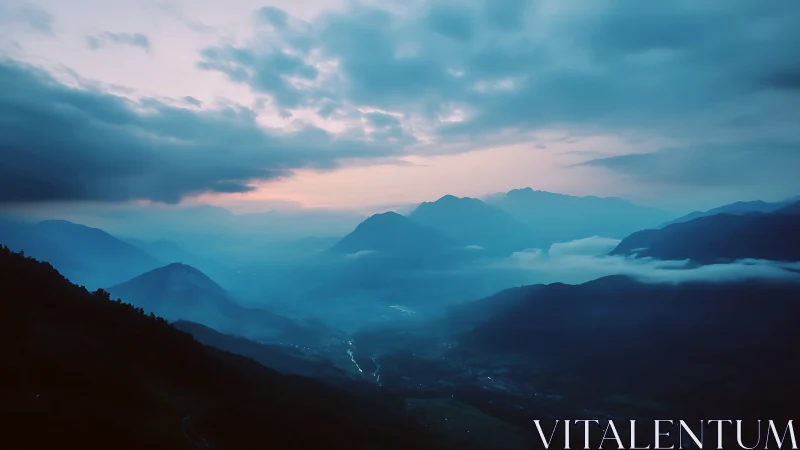 Blue hour aerial mountain valley under stratified cloud deck