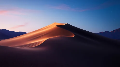 Soft sunrise glow over quiet desert sand dune ridge.