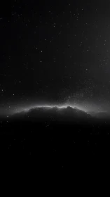 Monochrome starfield extends above silhouetted cloud layer