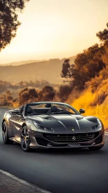 Low-angle Ferrari convertible on curving road under warm sunset light