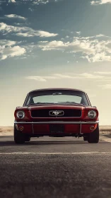 Front view of red classic Ford Mustang on open highway.