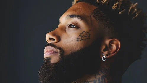 Bearded man in profile gazes upward against dark background