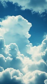 Towering cumulus clouds under deep blue summer sky.