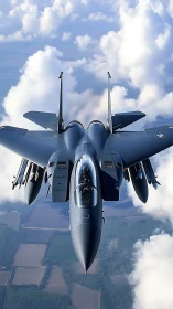 Tactical jet fighter in high-altitude pass above clouds.