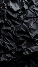 Black crumpled paper texture with deep folded shadows.